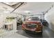 Spacious garage with a red GMC vehicle, storage space, and ample lighting at 11231 Sun Tree Rd, Hudson, FL 34667