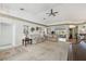 Bright living room features neutral carpet, a ceiling fan, and leads to a dining area at 11231 Sun Tree Rd, Hudson, FL 34667