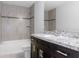 Bathroom with dark wood vanity and tiled tub/shower with decorative band at 11388 Paramount Ave, Weeki Wachee, FL 34614