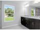 Bathroom featuring double sink vanity with granite countertop and large mirror at 11388 Paramount Ave, Weeki Wachee, FL 34614
