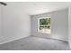 Bright bedroom featuring neutral carpeting, light gray walls, and a window that invites ample natural light at 11388 Paramount Ave, Weeki Wachee, FL 34614