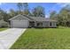 Charming single-story home featuring a well-maintained lawn, attached two-car garage, and freshly painted exterior at 11388 Paramount Ave, Weeki Wachee, FL 34614