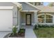 Close-up of the front door of a home with a decorative glass pane, sidelight window, and manicured landscaping at 11388 Paramount Ave, Weeki Wachee, FL 34614