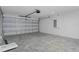 Open garage featuring an insulated door, concrete flooring, and an electric panel at 11388 Paramount Ave, Weeki Wachee, FL 34614