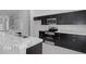 Modern kitchen with black cabinetry, granite countertops, and stainless steel appliances at 11388 Paramount Ave, Weeki Wachee, FL 34614