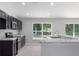 Open kitchen with black cabinetry, stainless steel appliances, and bright granite countertops at 11388 Paramount Ave, Weeki Wachee, FL 34614