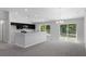 Open-concept living area showcasing a kitchen with dark cabinets, light countertops, and seamless connection to the living space at 11388 Paramount Ave, Weeki Wachee, FL 34614