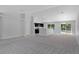Bright, open living area featuring neutral carpeting, abundant natural light, and a seamless flow to the kitchen at 11388 Paramount Ave, Weeki Wachee, FL 34614