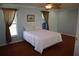 Bedroom with hardwood floors, a ceiling fan, and lots of natural light from the two windows at 11480 Emerald Ridge Ct, Spring Hill, FL 34609