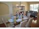 The dining area has a glass table set, chandelier and hardwood floors with easy access to the living room and pool at 11480 Emerald Ridge Ct, Spring Hill, FL 34609