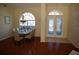 Open-concept dining room and foyer, featuring a chandelier over the dining table and decorative glass front doors at 11480 Emerald Ridge Ct, Spring Hill, FL 34609