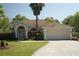 Charming single-story home with a two-car garage, mature landscaping, and a welcoming front entrance at 11480 Emerald Ridge Ct, Spring Hill, FL 34609