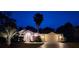 Charming single-story home with beautiful landscaping, a palm tree and inviting curb appeal at twilight at 11480 Emerald Ridge Ct, Spring Hill, FL 34609