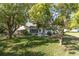 Spacious backyard with lush green lawn, mature trees, and a patio set, ideal for outdoor living at 11526 Forest Run Ct, Port Richey, FL 34668