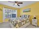 Bedroom features a ceiling fan, natural light, a large window and a bed with decorative pillows at 11526 Forest Run Ct, Port Richey, FL 34668