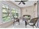 Cozy Florida room features wicker seating, tile flooring, and view of the lush backyard landscaping at 11526 Forest Run Ct, Port Richey, FL 34668