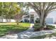 Well-maintained front yard with lush green grass, mature trees, and a neatly landscaped garden at 11526 Forest Run Ct, Port Richey, FL 34668