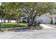 Home featuring a mature tree in the front yard with green grass and tidy landscaping at 11526 Forest Run Ct, Port Richey, FL 34668