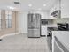 Bright kitchen features white cabinets, stainless steel appliances, tile backsplash, and tile floors at 11526 Forest Run Ct, Port Richey, FL 34668