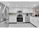 Modern kitchen with white cabinets, stainless steel appliances, and tile flooring at 11526 Forest Run Ct, Port Richey, FL 34668