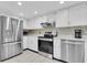 Clean kitchen with stainless steel appliances, white cabinetry, and tiled backsplash at 11526 Forest Run Ct, Port Richey, FL 34668