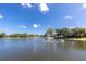 A tranquil lake featuring a central fountain, surrounded by lush greenery and picturesque waterfront homes at 11526 Forest Run Ct, Port Richey, FL 34668