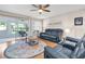 Cozy living room featuring a ceiling fan, hardwood floors, and sliding glass doors to the patio at 11526 Forest Run Ct, Port Richey, FL 34668