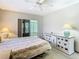Comfortable bedroom boasts sliding glass door and a large dresser with lamp at 11917 Bayonet Ln # 11917, New Port Richey, FL 34654