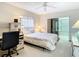 Bright bedroom features a queen bed, desk, and sliding glass door to the lanai at 11917 Bayonet Ln # 11917, New Port Richey, FL 34654