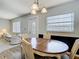 Dining area featuring a wooden table, four chairs, chandelier, and a view into the living room at 11917 Bayonet Ln # 11917, New Port Richey, FL 34654