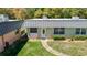 Inviting exterior view of home featuring a metal roof, lush greenery, and a curved walkway at 11917 Bayonet Ln # 11917, New Port Richey, FL 34654