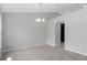 Open dining room with neutral walls, tile flooring, modern chandelier, and arched doorway at 13066 Nusser Ave, Weeki Wachee, FL 34614
