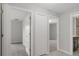 Bright hallway leading to bedrooms with plush carpeting and a modern bathroom at 13066 Nusser Ave, Weeki Wachee, FL 34614