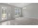 Bright living room featuring tile flooring, a decorative front door, and large windows for ample natural light at 13066 Nusser Ave, Weeki Wachee, FL 34614
