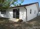 White stucco house featuring a sliding glass door, brown gutters, and a well-maintained yard at 13610 Claudia Dr, Hudson, FL 34667