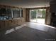 Open living room with sliding glass door, tile flooring, and large windows at 13610 Claudia Dr, Hudson, FL 34667