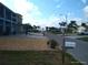 Neighborhood street view, landscaped yards, and a glimpse of the beach in the distance at 13610 Claudia Dr, Hudson, FL 34667