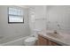 Bright bathroom with tiled walls, shower/tub, and sink at 13643 Pimberton Dr, Hudson, FL 34669