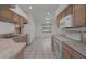 A sunny kitchen featuring white appliances, tile floors, and wooden cabinets at 13643 Pimberton Dr, Hudson, FL 34669