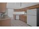 Open-concept kitchen with ample wood cabinetry, white appliances and view to dining room at 13643 Pimberton Dr, Hudson, FL 34669