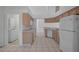 Open-concept kitchen with wood cabinets and white appliances near laundry room at 13643 Pimberton Dr, Hudson, FL 34669