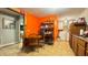 Eat-in kitchen with warm wood cabinets and tile flooring adjacent to laundry room at 18044 Nicholas Ave, Brooksville, FL 34604