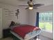 Comfortable bedroom with motivational decor, a ceiling fan, and a bright window, creating a positive environment at 18336 Macek Rd, Weeki Wachee, FL 34614