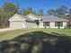 Charming single-story home with a well-manicured lawn and gray facade at 18336 Macek Rd, Weeki Wachee, FL 34614