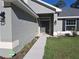 Close up of front door and walkway lined with well manicured landscaping at 18336 Macek Rd, Weeki Wachee, FL 34614