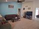 Spacious living room features a brown leather couch, ceiling fan and a large television at 18336 Macek Rd, Weeki Wachee, FL 34614