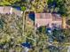 An aerial view shows the layout of the house and its position among mature trees at 1870 Whispering Way, Tarpon Springs, FL 34689