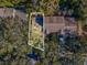 An aerial view shows the layout of the house and its position among mature trees at 1870 Whispering Way, Tarpon Springs, FL 34689