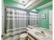 Bathroom featuring a vanity with sink, toilet, and a tub with a gray-and-white striped shower curtain at 1870 Whispering Way, Tarpon Springs, FL 34689