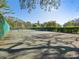 Well-maintained community tennis court surrounded by lush greenery at 1870 Whispering Way, Tarpon Springs, FL 34689